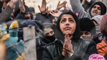 Una mujer protesta detrás de la valla por las restricciones en la frontera entre Grecia y Macedonia.