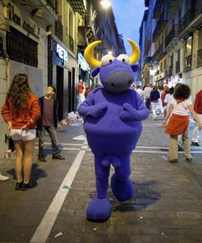 Una persona disfrazada de un toro de la marca Kukuxumusu pasea por Pamplona en los Sanfermines de 2012.