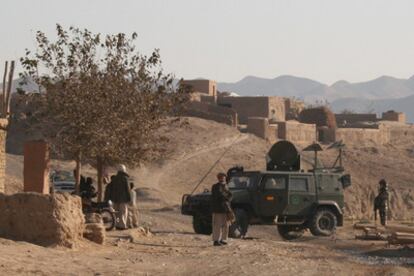 Un soldado español y varios ciudadanos afganos junto a un blindado LMV Lince desplegado en Afganistán.