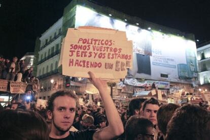 Un joven exhibe un cartel contra la clase política en la concentración de anoche en la Puerta del Sol.