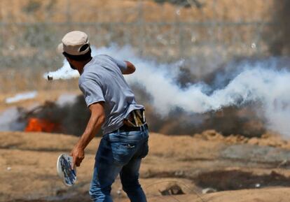 Un protestante palestino golpea con una raqueta un bote de gas lacrimógeno durante los enfrenamientos contra las tropas israelíes.
