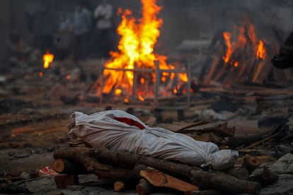 El cuerpo de una persona muerta a causa del coronavirus, en una pira funeraria durante una incineración masiva en un crematorio en Nueva Delhi (India), el 1 de mayo de 2021.