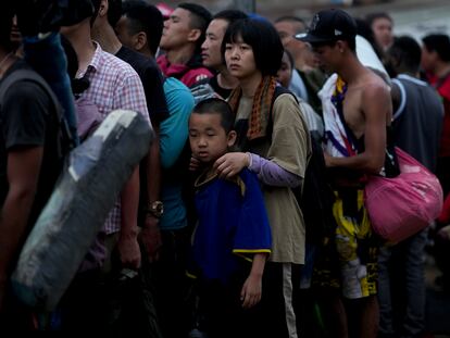 Chinese migrants line up to take a boat to Lajas Blancas after walking across the Darien Gap in Bajo Chiquito, Panama, Sunday, May 7, 2023.