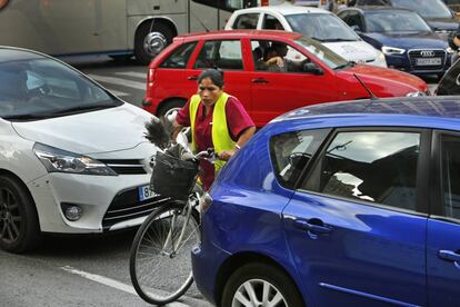 Una ciclista intenta cruzar entre los vehículos en el día europeo sin coches.