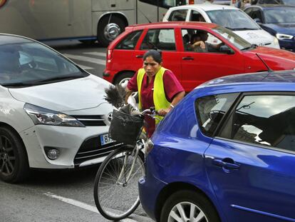 Una ciclista intenta cruzar entre los veh&iacute;culos en  el d&iacute;a europeo sin coches.