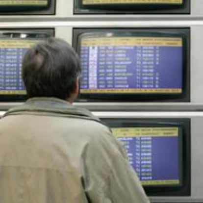 Un pasajero mira los paneles del aeropuerto de Barajas.