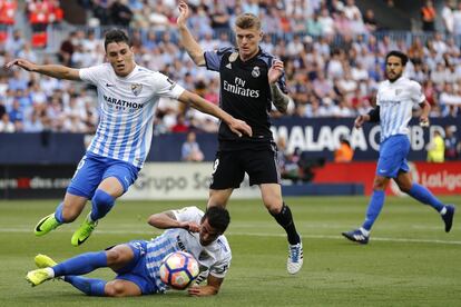 Los defensas del Málaga, Federico Ricca  y Luis Hernández, luchan por el balón ante el centrocampista alemán del Real Madrid Toni Kroos.