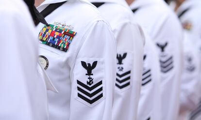 Enlisted sailors line up and wait to march on the field at Sun Life Stadium before the NFL football game in Miami, Nov. 13, 2011