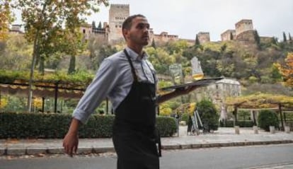 Un camarero en un restaurante del paseo de los Tristes en Granada.  