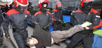 Agentes de la Ertzaintza detienen a un hombre que participaba en un piquete que trataba de bloquear los autobuses urbanos de San Sebastián.