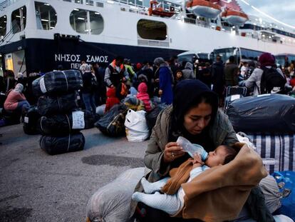 Una mujer alimenta a su bebé tras desembarcar en la isla griega de Lesbos. 