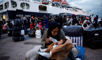Una mujer alimenta a su bebé tras desembarcar en la isla griega de Lesbos.