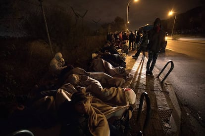 Migrants sleep on the street outside the immigration office.