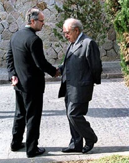 El consejero Antoni Castells y Jordi Pujol se saludan tras el funeral.