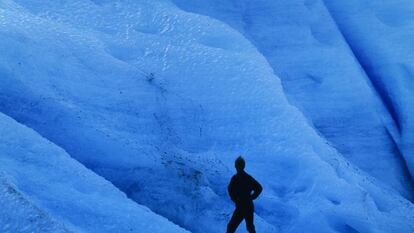 Um turista diante do gelo azul do glaciar Svartisen, ao norte de Noruega.