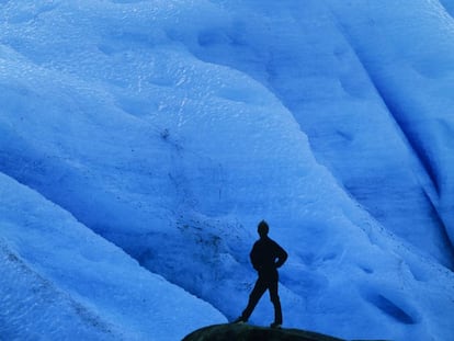 Un turista ante el hielo azul del glaciar Svartisen, al norte de Noruega.