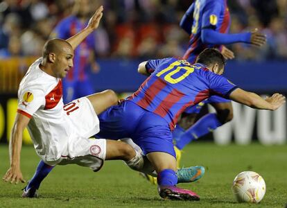 El centrocampista del Levante Vicente Iborra pelea un balón con el delantero argelino del Olympiacos Rafik Djebbour.