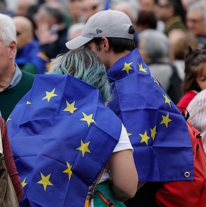 Dos manifestantes asisten a la protesta en Roma con la bandera de Europa.