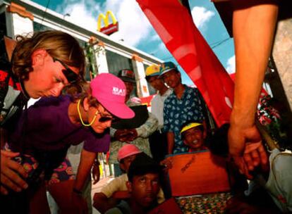 Turistas en Bali, Indonesia, junto a unos vendedores ambulantes