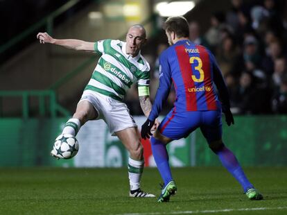Scott Brown (izquierda) del Celtic se hace con el control del balón ante Gerard Piqué del FC Barcelona.