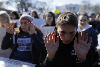 Na praça em frente à Casa Branca protestam centenas de estudantes aos gritos de "Nunca mais!" e "Basta!". Na imagem, dois jovens levantam as mãos, nas quais está escrito "Não dispare", em frente à Casa Branca, em Washington.