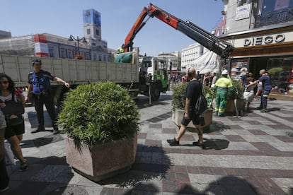 Policía y bomberos colaboran en la colocación de las nuevas jardineras instaladas en las calles Montera y El Carmen, en Madrid.