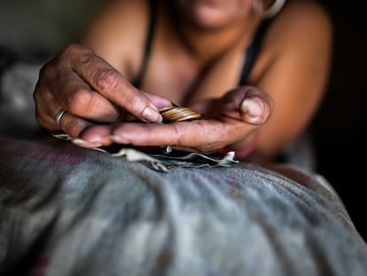 Una mujer cuenta monedas en San Salvador (El Salvador).