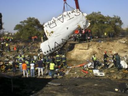 Una grúa levanta parte del fuselaje de la aeronave.