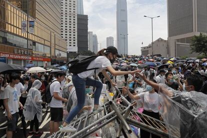 Una manifestante pasa por encima de una valla en las protestas de este miércoles en Hong Kong. En dos horas, la zona en torno al Parlamento quedó casi vacía de manifestantes. En cuatro, los agentes antidisturbios seguían usando los gases lacrimógenos para despejar las calles y avenidas adyacentes. Aunque los jóvenes continuaban agrupándose en otros puntos de la ciudad.