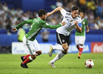 El centrocampista alemán Julian Draxler (derecha) lucha por el balón con el centrocampista mexicano Jonathan dos Santos.