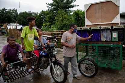 Un padre de alumno revisa carpetas con materiales educativos en un 'rickshaw', en Porac (Filipinas).