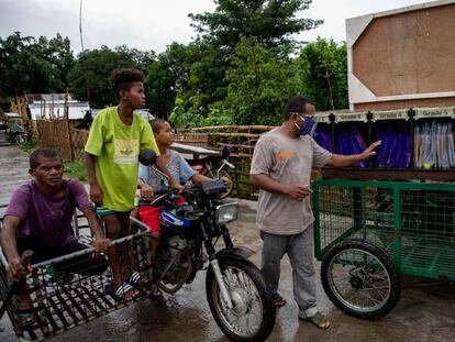 Un padre de alumno revisa carpetas con materiales educativos en un 'rickshaw', en Porac (Filipinas).