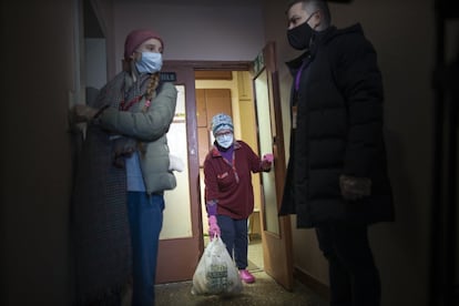 Una jubilada recoge una bolsa con productos traídos por los voluntarios en Moscú (Rusia). En el marco de la acción benéfica Voluntarios de Año Nuevo del movimiento Estamos Juntos los voluntarios distribuyen alimentos, medicinas y otras cosas necesarias a las personas mayores.