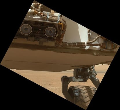 La parte inferior del veh&iacute;culo &lsquo;Curiosity&rsquo; y una de las ruedas fotografiadas con la c&aacute;mara situada en el extremo del brazo articulado.