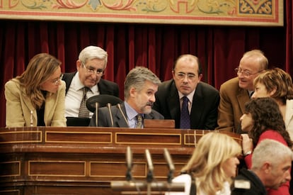  Pleno del Congreso de los Diputados en el que se aprobaron el Proyecto de Ley de Presupuestos Generales del Estado para 2005 y la Ley Integral  contra la Violencia de Género. En la foto, los miembros de la mesa discuten una circunstancia. De izquierda a derecha: Carme Chacón, PSOE, vicepresidenta primera; Gabriel Cisneros, PP, vicepresidente tercero; Manuel Marín, PSOE, presidente; Ignacio Gil Lázaro, PP, vicepresidente cuarto; Jordi Vilajoana Rovira, CiU, vicepresidente segundo; Celia Villalobos, PP, secretaria segunda e Isaura Navarro Casilla, IU, secretaria cuarta, en 2004.