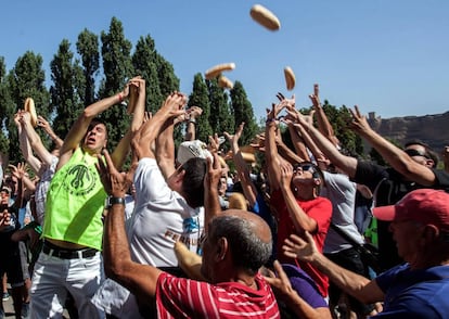 Romeros de Quel (La Rioja) compiten por apoderarse de los bollos de pan y raciones de queso en la fiesta de la localidad.