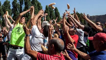 Romeros de Quel (La Rioja) compiten por apoderarse de los bollos de pan y raciones de queso en la fiesta de la localidad.