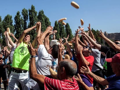 Romeros de Quel (La Rioja) compiten por apoderarse de los bollos de pan y raciones de queso en la fiesta de la localidad.