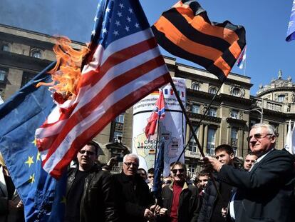 El ultranacionalista serbio (a la derecha) quema la bandera de EEUU en una manifestación el 24 de marzo en Belgrado.