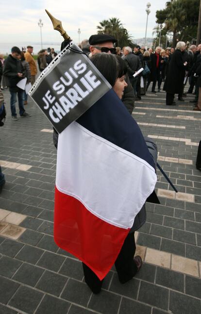 Una mujer sostiene una bandera francesa y una pancarta en la que se lee "Yo soy Charlie" durante una manifestación en silencio en Niza.