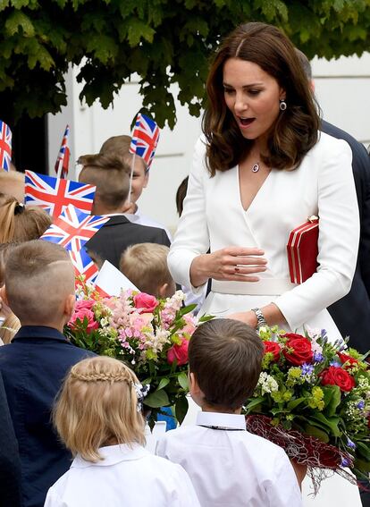 Kate Middleton, duquesa de Cambridge, soprendida ante la entrega de un ramo de flores como bienvenida a Polonia.