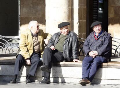 Tres ancianos toman el sol en la plaza Nueva de Bilbao.