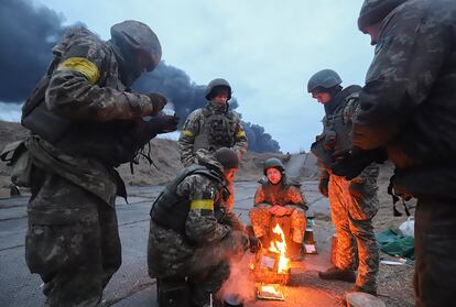 Soldados ucranios se calientan en una hoguera en las inmediaciones de Kiev, Ucrania este domingo.