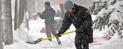 Una mujer retira la nieve acumulada cerca de su casa en Milwaukee