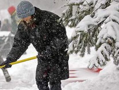 Una mujer retira la nieve acumulada cerca de su casa en Milwaukee