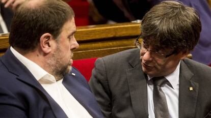 Carles Puigdemont charla con Oriol Junqueras durante el pleno en el parlamento de Catalu&ntilde;a.