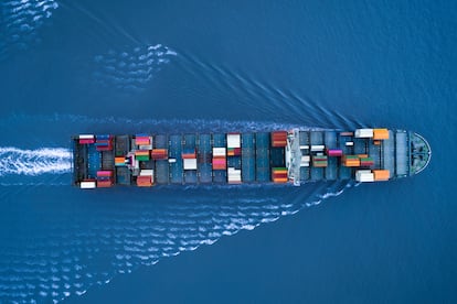 Large container ship is approching the port full loaded with containers and cargo - aerial - top down view. Shanghai, Shanghai, China