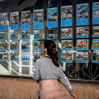 Una mujer pasa junto a una inmobiliaria en Santander, el 23 de febrero de 2025.