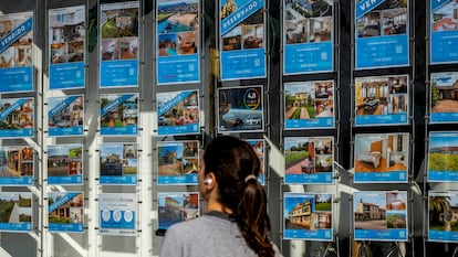 Una mujer pasa junto a una inmobiliaria en Santander.