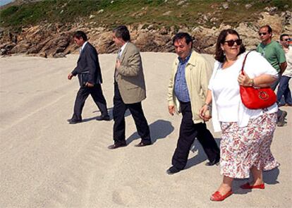 La ministra de Medio Ambiente visita la playa de Lourido, en Muxía, acompañada de autoridades locales.